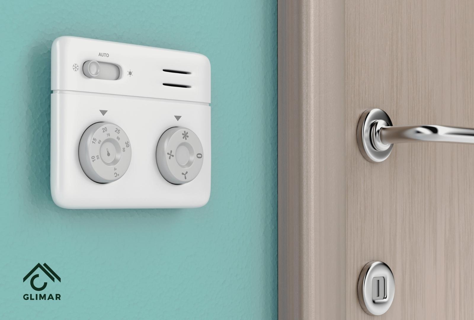 panel sterowania klimatyzacji  przymocowany na zielonej ścianie pomieszczenia